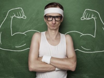 Funny sport nerd with fake muscle drawn on the chalkboard