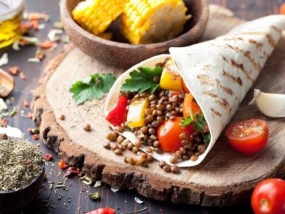Vegan tortilla wrap, roll with grilled vegetabes, lentil, corn cob.