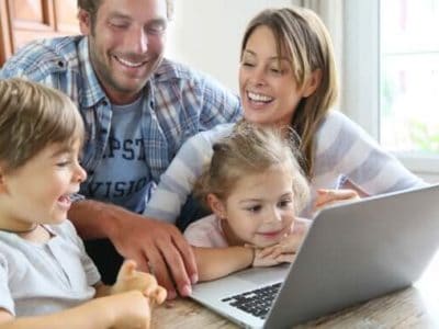 Familie mit Kindern sitzt vor Computer