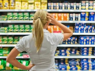 Frau vor dem Supermarkt-Kühlregal