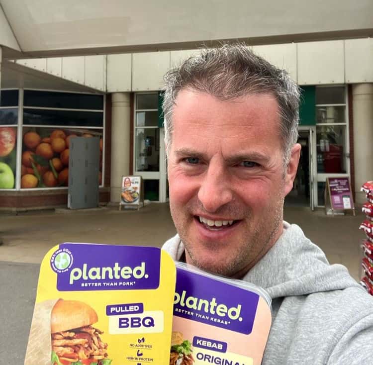 Rob Reames of Planted in front of supermarket with products