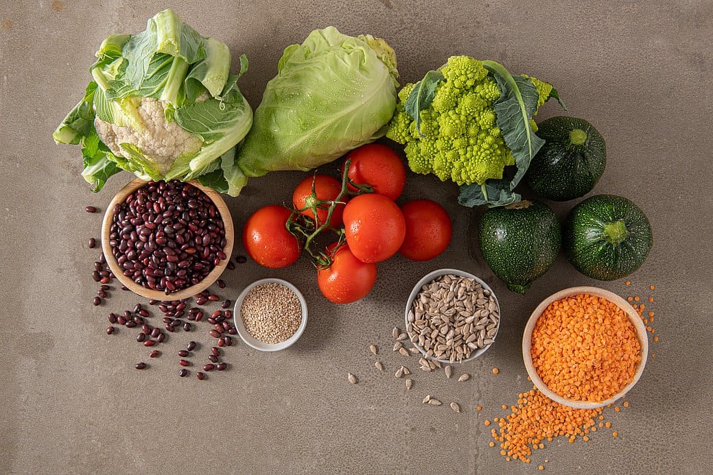 Vegetables, legumes, and seeds on top of a table.