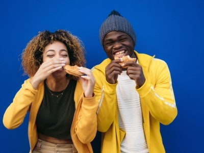 Young couple eating burger outdoors, APA