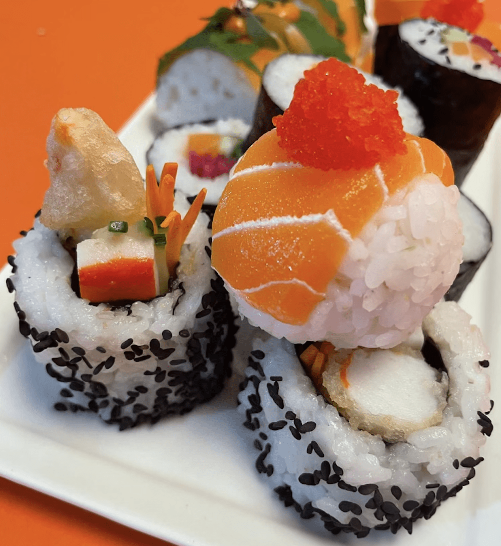 three salmon sushi rolls on a plate
