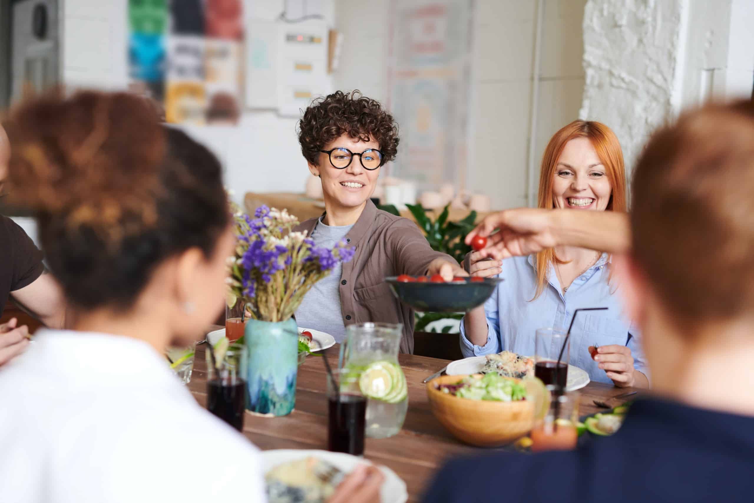 Young people sharing food around table